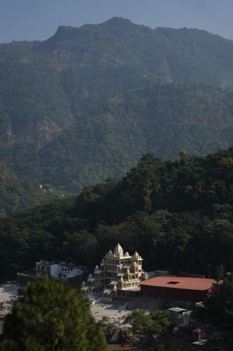 un gran edificio blanco frente a una montaña en Art Bliss Hostel, en Rishīkesh