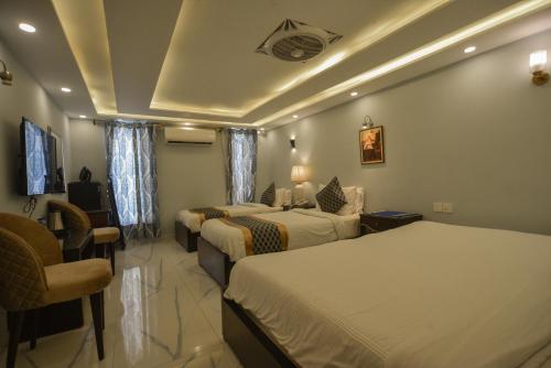 Pokój hotelowy z 2 łóżkami i krzesłem w obiekcie Swisstel Cottage w mieście Karaczi