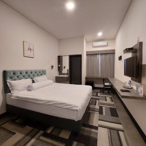 een slaapkamer met een groot bed en een bureau bij 3 Point Syariah Residence in Jakarta