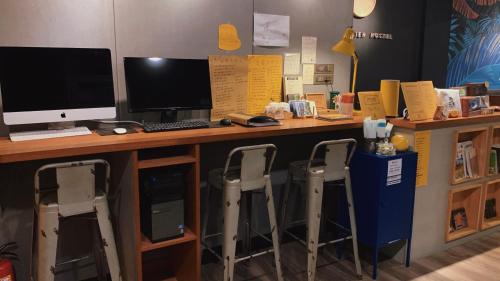 a desk with a computer and two monitors on it at KID Hualien Hostel in Hualien City