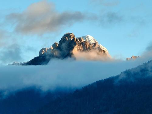 a mountain in the middle of a fog covered valley at Hotel Nevada in Tarvisio