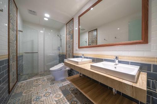 a bathroom with two sinks and a shower and a toilet at 歐堤斯旅店 Otis Inn-花蓮民宿2531-2541-2555-2556號 in Hualien City