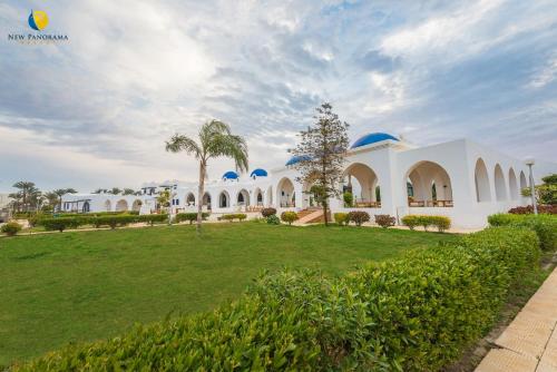 a large white house with a green lawn at New Panorama Resort in Fayoum Center