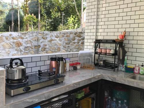 a kitchen with a stove top oven next to a sink at Dango1881muslim riverstay in Padang Rengas