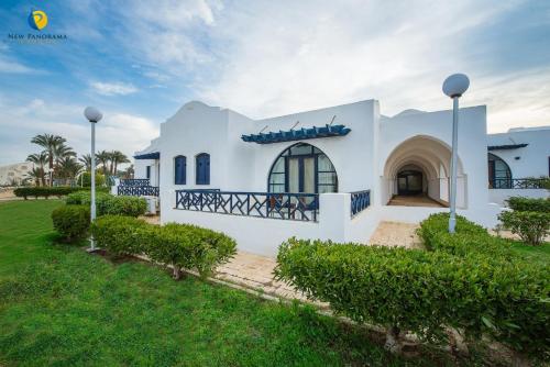 a large white house with a green yard at New Panorama Resort in Fayoum Center