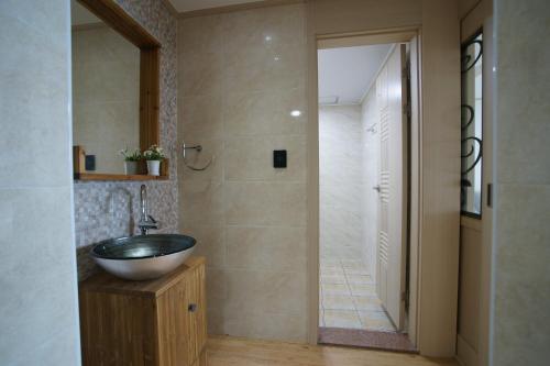 a bathroom with a sink and a walk in shower at The Beach Pension in Jeju