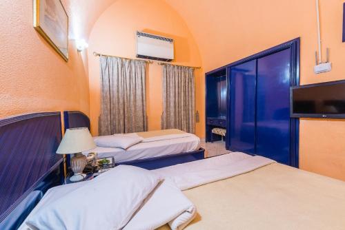 a hotel room with two beds and a tv at New Panorama Resort in Fayoum Center