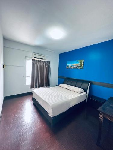 Un dormitorio con una cama con paredes azules y una ventana en PD MARINA RESORT 2 en Port Dickson