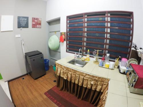 a kitchen with a sink and a table in a room at D HOMESTAY SERI ISKANDAR in Seri Iskandar