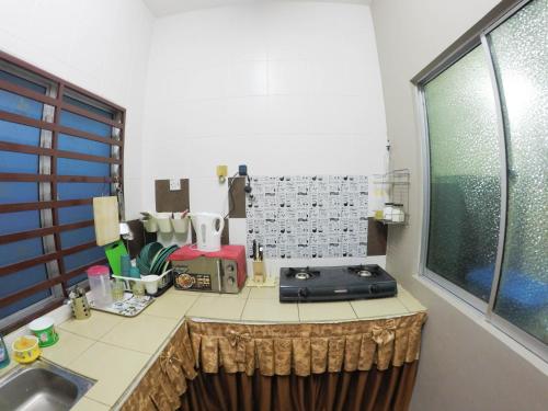 een keuken met een aanrecht met een wastafel en een raam bij D HOMESTAY SERI ISKANDAR in Seri Iskandar