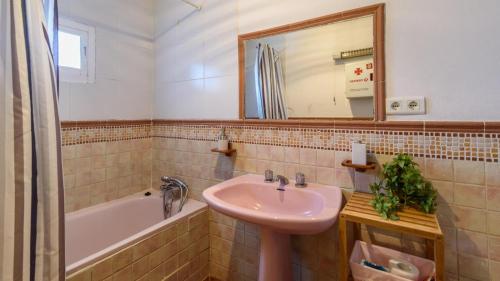 ein Badezimmer mit einem Waschbecken, einer Badewanne und einem Spiegel in der Unterkunft Casa Rural la Sacri Guaro by Ruralidays in Guaro