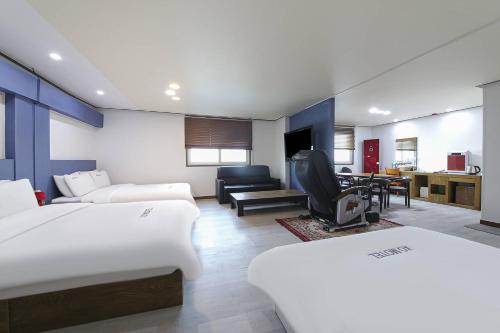 1 dormitorio con 2 camas y sala de estar en XO Hotel en Jeonju