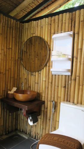 a bathroom with a wooden sink in a bamboo wall at Touch Glamping Koh Yao Noi ทัช แกรมปิ้ง เกาะยาวน้อย in Ko Yao Noi