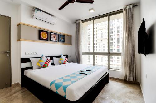 a bedroom with a large bed with a large window at OYO Home Elegant Stay Hiranandani in Mumbai