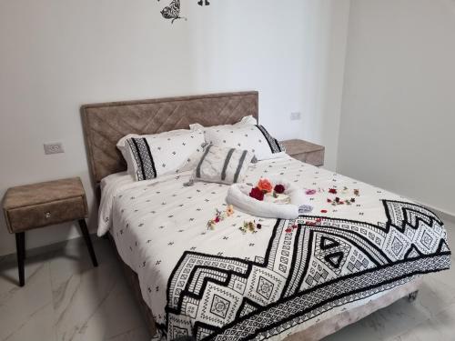 a bed with a blanket and a bowl of flowers on it at צימר נתיב המעיין in Ein Kinya