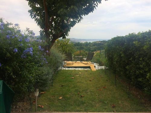 a view of a garden with a bench in the grass at Il Ciliegio - House with Garden & Wonderful View in Pietra la Croce