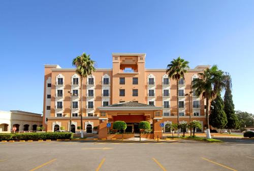 a large building with a parking lot in front of it at iStay Hotel Ciudad Victoria in Ciudad Victoria