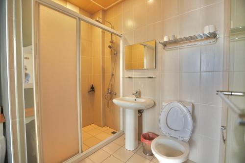 ein Bad mit einer Dusche, einem WC und einem Waschbecken in der Unterkunft 好窩旅店 in Altstadt von Hengchun
