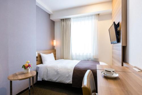 銚子市にある銚子プラザホテルのベッドと窓が備わるホテルルーム
