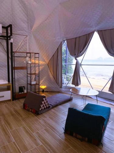 a room with a tent with two beds and a table at Touch Glamping Koh Yao Noi ทัช แกรมปิ้ง เกาะยาวน้อย in Ko Yao Noi