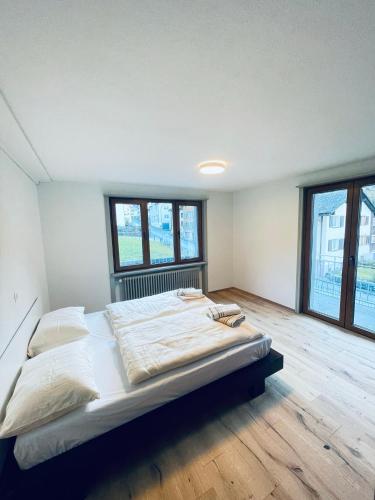 Cama grande en habitación con ventanas en Ferienhaus Granula en Linthal