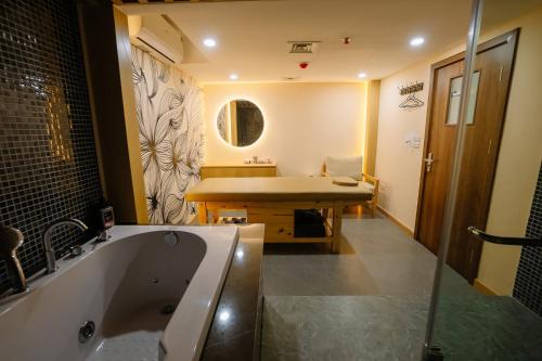 a bathroom with a bath tub and a sink at Bao Son International Hotel in Hanoi