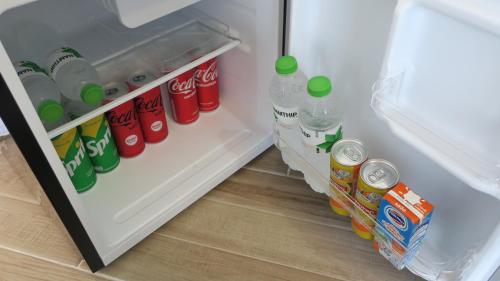 an open refrigerator with bottles of soda and milk at Touch Glamping Koh Yao Noi ทัช แกรมปิ้ง เกาะยาวน้อย in Ko Yao Noi