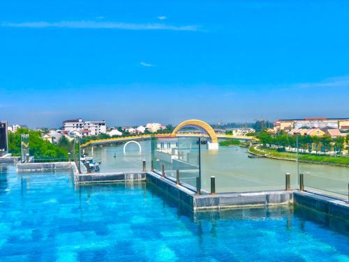 a large body of water with a bridge and a river at Little Riverside Hoi An . A Luxury Hotel & Spa in Hoi An