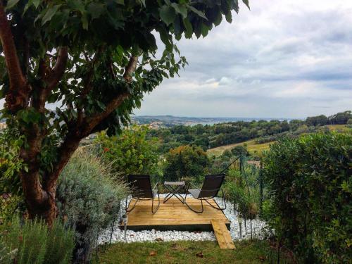 une table et deux chaises assises sur un banc en bois dans l'établissement Il Ciliegio - House with Garden & Wonderful View, à Pietra la Croce