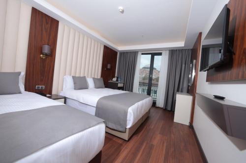 a hotel room with two beds and a flat screen tv at Shining Star Hotel in Istanbul