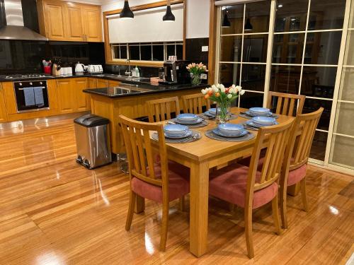 a kitchen with a wooden table with chairs and a table at Style/Comfort/Spacious 4 bedroom house plus study in Melbourne