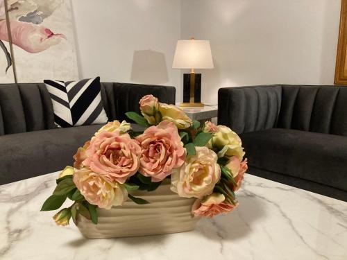 a vase filled with pink flowers on a table at Style/Comfort/Spacious 4 bedroom house plus study in Melbourne