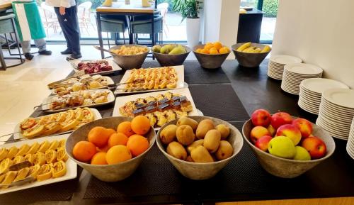 a table topped with bowls of fruits and pastries at Kraljevi Konaci Olja in Zlatibor