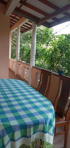 a porch with a checkered table and chairs at Pravindi Guest Home in Mirissa