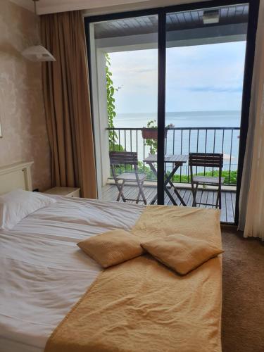 a bedroom with a bed with a view of the ocean at Regina Maria Spa Design Hotel in Balchik