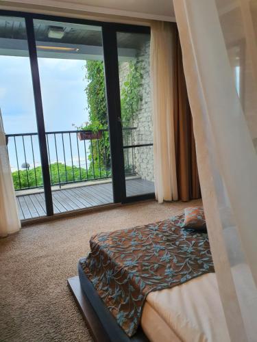 a bedroom with a bed and a large window at Regina Maria Spa Design Hotel in Balchik
