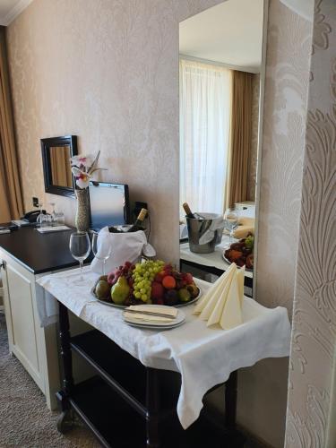 a table with a plate of fruit on it in a hotel room at Regina Maria Spa Design Hotel in Balchik