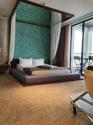 a bedroom with a bed with a green wall at Regina Maria Spa Design Hotel in Balchik