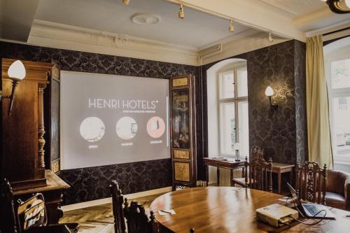 a meeting room with a table and a sign on the wall at Henri Hotel Berlin Kurfürstendamm in Berlin