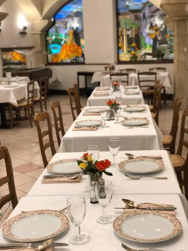a dining room with white tables with flowers on them at Grand Hôtel d'Espagne in Lourdes