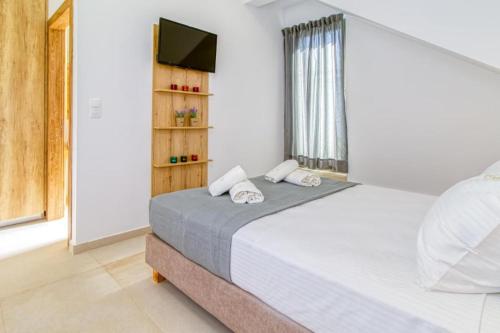 1 dormitorio con 1 cama grande y TV en Cocoon Luxury Villas en Maleme