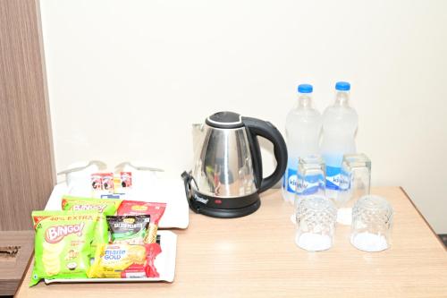 a table with a tea kettle and drinks on it at PIPUL PADMAJA PRIDE in Cuttack