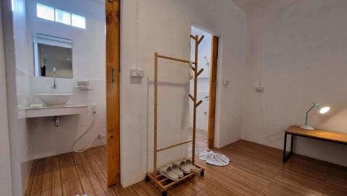 a bathroom with a sink and a shower with shoes on the floor at OldTown Boutique House Sukhothai in Sukhothai
