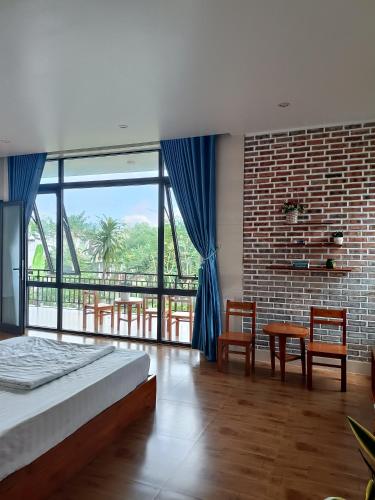 a bedroom with a bed and a table and chairs at Hugo Homestay in Phong Nha