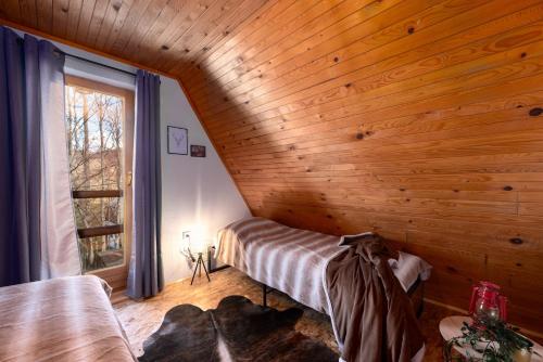 een slaapkamer met een bed in een houten muur bij Cottage Gordana in Begovo Razdolje