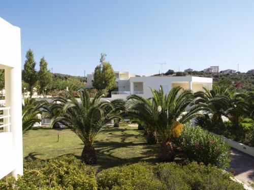 a row of palm trees in front of a building at Eleftheria Hotel in Agia Marina Nea Kydonias