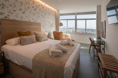 Un dormitorio con una cama grande con toallas. en Apartamento La Atalaya de Cádiz, en Cádiz