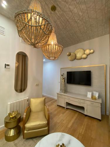ein Wohnzimmer mit einem TV und einem Stuhl in der Unterkunft Apartamento cerca Plaza Mayor in Madrid