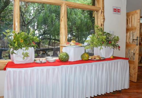 a table with plants in white vases on it at Dovenest Lodge in Naivasha