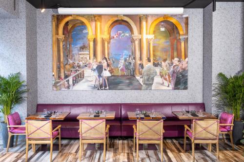 Une salle à manger ornée d'une peinture murale dans l'établissement Theory Hotel, à Tbilissi